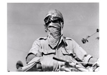 Cpl. R. Atkinson, R.E., of 3 Kirkdale Drive, Sheffield, 9, protects his face as best he can from the ever-present dust in this sector - August 27th , 1944